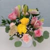 Mixed bouquet of pink and yellow flowers in a white vase