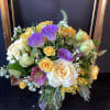 Bouquet of roses and purple lisianthus in a clear glass vase