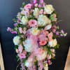 Pink and white floral standing spray with a ribbon bow