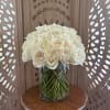 White roses arranged in a clear glass vase