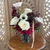 White and burgundy flowers arranged in a patterned vase