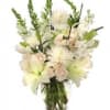 White floral arrangement in a glass vase with lilies and spiky blooms