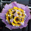 Golden sunflowers, lavender roses and white and lilac baby&rsquo;s breath create a