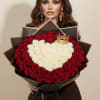 Woman holding a large heart-shaped bouquet of red and white roses