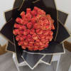 Bouquet of orange roses wrapped in black paper with gold trim