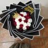 Bouquet of red and white roses with a gold birthday topper