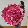 Large bouquet of pink and peach roses wrapped in bright pink paper