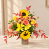 Yellow sunflowers and mixed blooms in a square metal vase