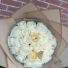 Bouquet of white roses wrapped in tan paper with gold butterfly accents