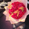 Heart-shaped bouquet of red roses with decorative butterflies in pink wrap