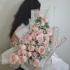 Large bouquet of pale pink roses with white baby's breath in white wrap