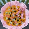Bouquet of yellow sunflowers and pink roses wrapped in pink paper