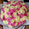Bouquet of pink and cream roses wrapped in black-edged paper