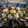 Large altar spray with white and blue hydrangeas, pink tulips, blue delphinium and green bells of Ireland