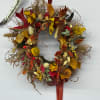 Autumn wreath with dried flowers and leaves on a white background