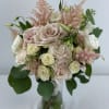 Bouquet of pale roses and pink astilbe in a glass vase