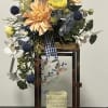 Mixed floral arrangement in a lantern-style frame with a memorial plaque