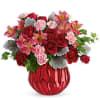 Red roses and pink flowers in a red glass vase