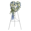 Heart-shaped floral wreath on a standing easel with blue and white flowers