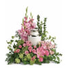 Pink floral arrangement around a silver urn
