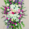 Tall standing floral spray with pink roses, white lilies, and purple spikes