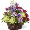 Mixed bouquet in a wicker basket with purple, pink, and green flowers