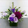 Purple and lavender flowers arranged in a green vase