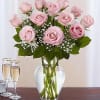 Pink roses arranged in a clear glass vase with baby's breath