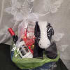 Gift basket with wine, chocolates, and a plush dog in clear wrap