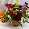 Cute 4 inch plastic pumpkin pail filled with assorted seasonal blooms and