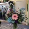 Mixed bouquet in a glass vase with pink gerbera, blue hydrangea, and white lilies