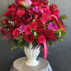 Large red rose arrangement in a white vase with pink orchids