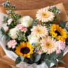 Mixed bouquet with sunflowers, pale gerberas, roses, and pink carnations