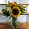 Sunflowers, hydrangea, orange roses, Hypericum berries, Lillies, solidago with wheat sprigs
arranged in