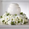 White floral arrangement around a white urn
