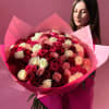 Large bouquet of pink, red, and white roses wrapped in pink paper