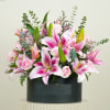 Pink lilies and roses arranged in a black box