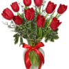 Red tulips arranged in a glass vase with a red ribbon