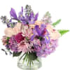 Purple and pink mixed bouquet in a clear glass vase