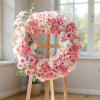 Pink and white floral wreath on a wooden easel