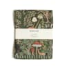 Folded woodland-print tea towel with mushrooms and trees