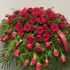 Large red rose arrangement with a ribbon and trailing roses