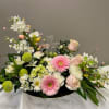 Pastel floral arrangement with a clear cross centerpiece