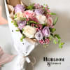 Bouquet of pastel roses wrapped in white paper with a twine tie