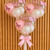 Three pink birthday balloons with butterfly prints and a ribbon bow
