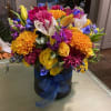 Colorful mixed bouquet in a black hatbox with a blue ribbon