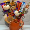 Candy bouquet in an orange mug with pumpkin decorations and ribbon