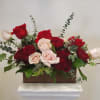 Red and blush roses arranged in a rectangular wooden box