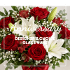 Red roses and white lilies in a glass vase with anniversary text overlay