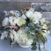 White floral bouquet in a low white container with eucalyptus